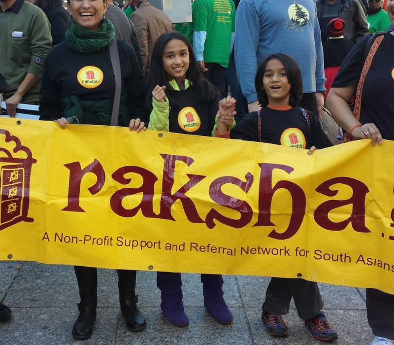 People holding a Raksha, Inc sign