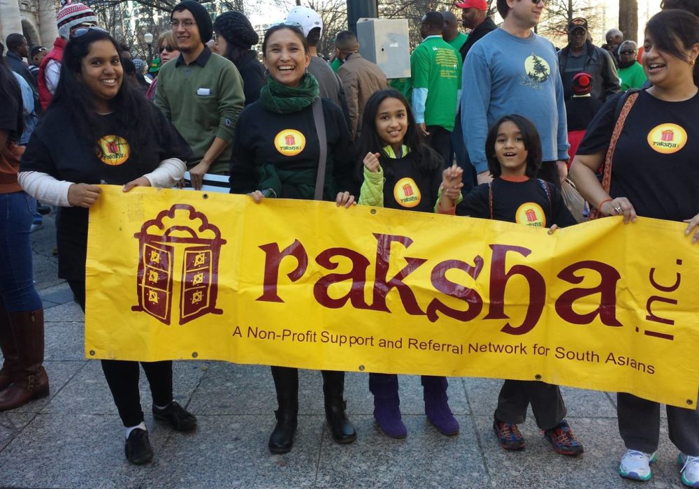 Women and young girls holding a raksha banner