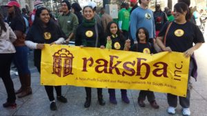 Women and young girls holding a raksha banner