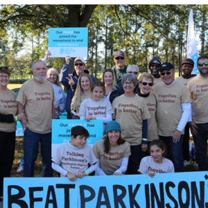 A group of people holding a Beat Parkinsons Sign outdoors