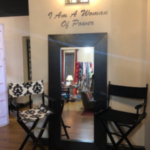 A fitting room with two chairs and the phrase I am a Woman of Power