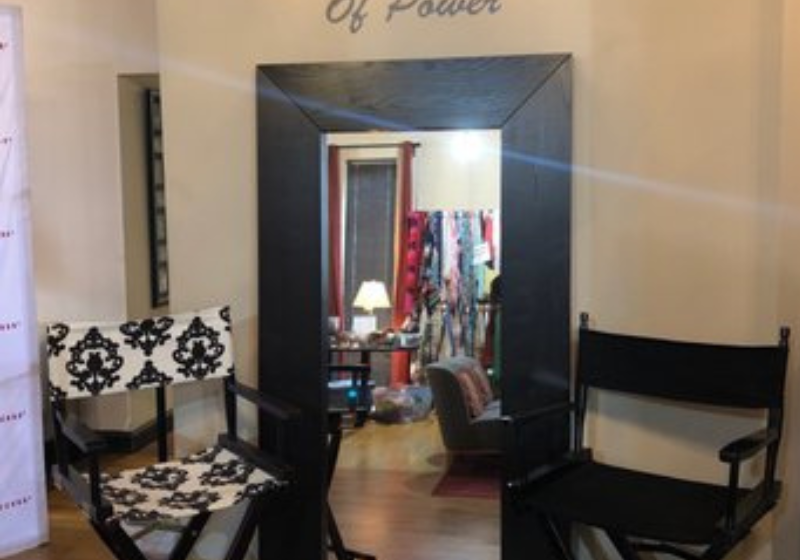 A fitting room with two chairs and the phrase I am a Woman of Power